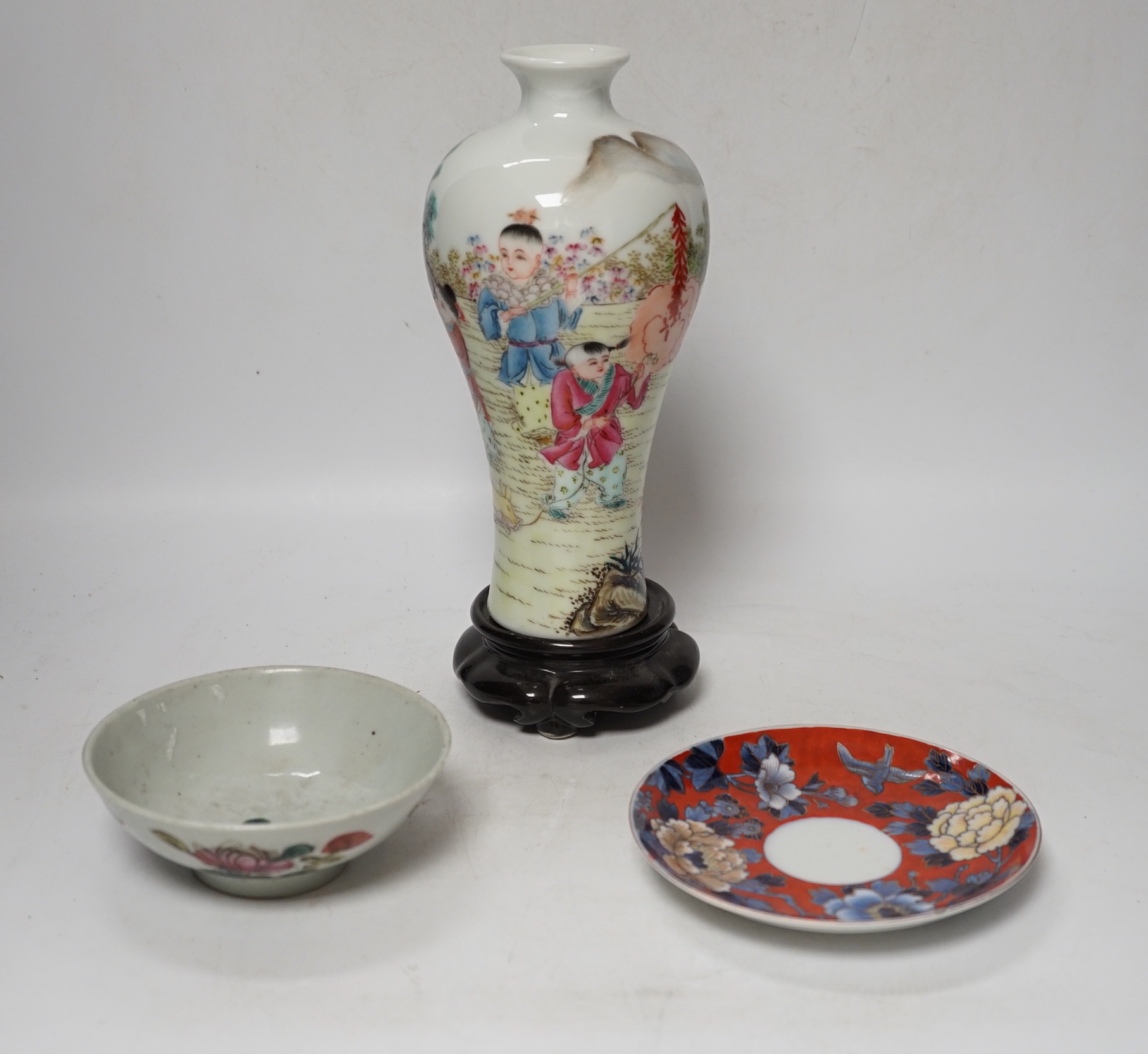 A Chinese famille rose vase, a rice dish, saucer and wooden stands